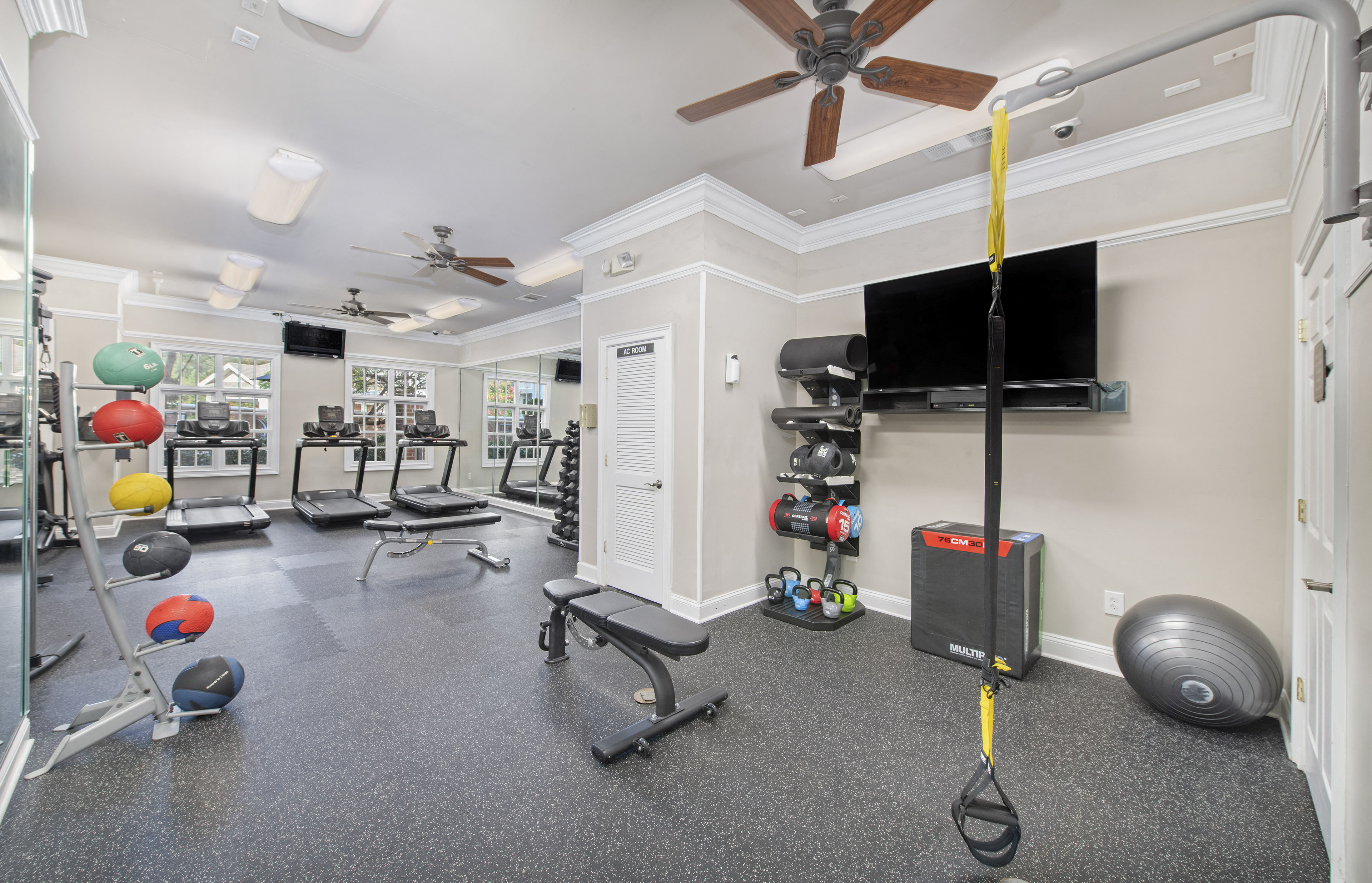the gym at the apartments with weights and a tv