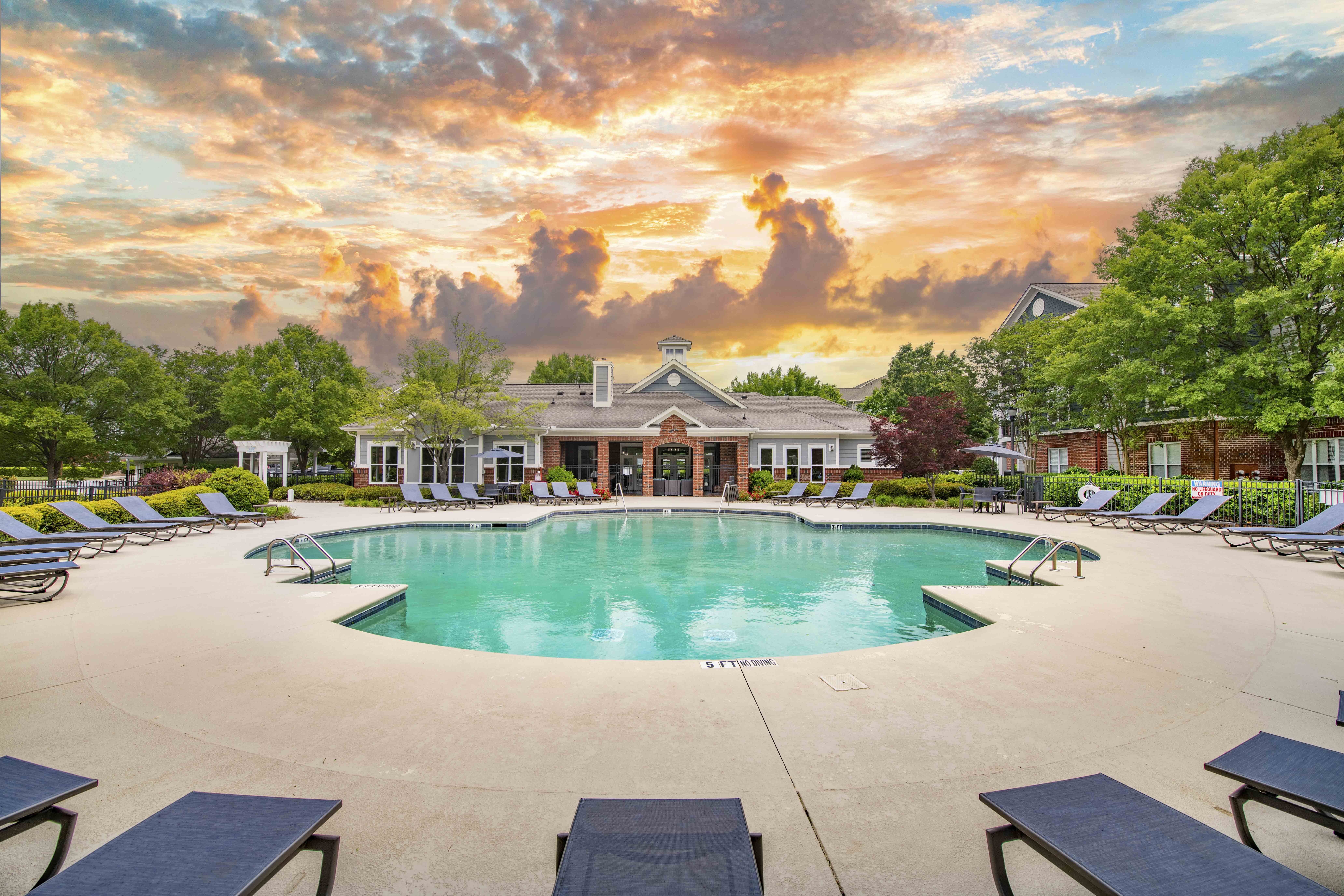 a swimming pool with lounge chairs and a building in the background