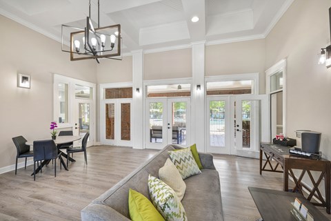 A living room with a grey couch and a chandelier.