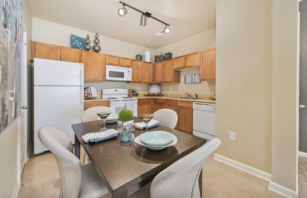 A kitchen with a table and chairs in the middle.
