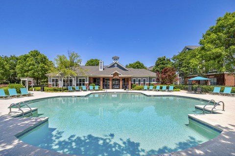A large swimming pool with a building in the background.