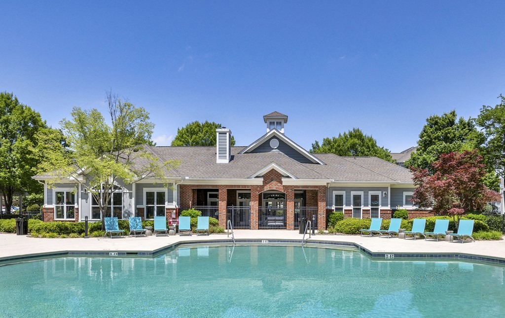A pool in front of a house with a gazebo.