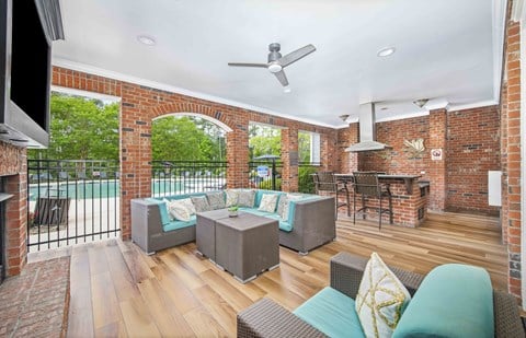 a living room with furniture and a brick wall and a balcony