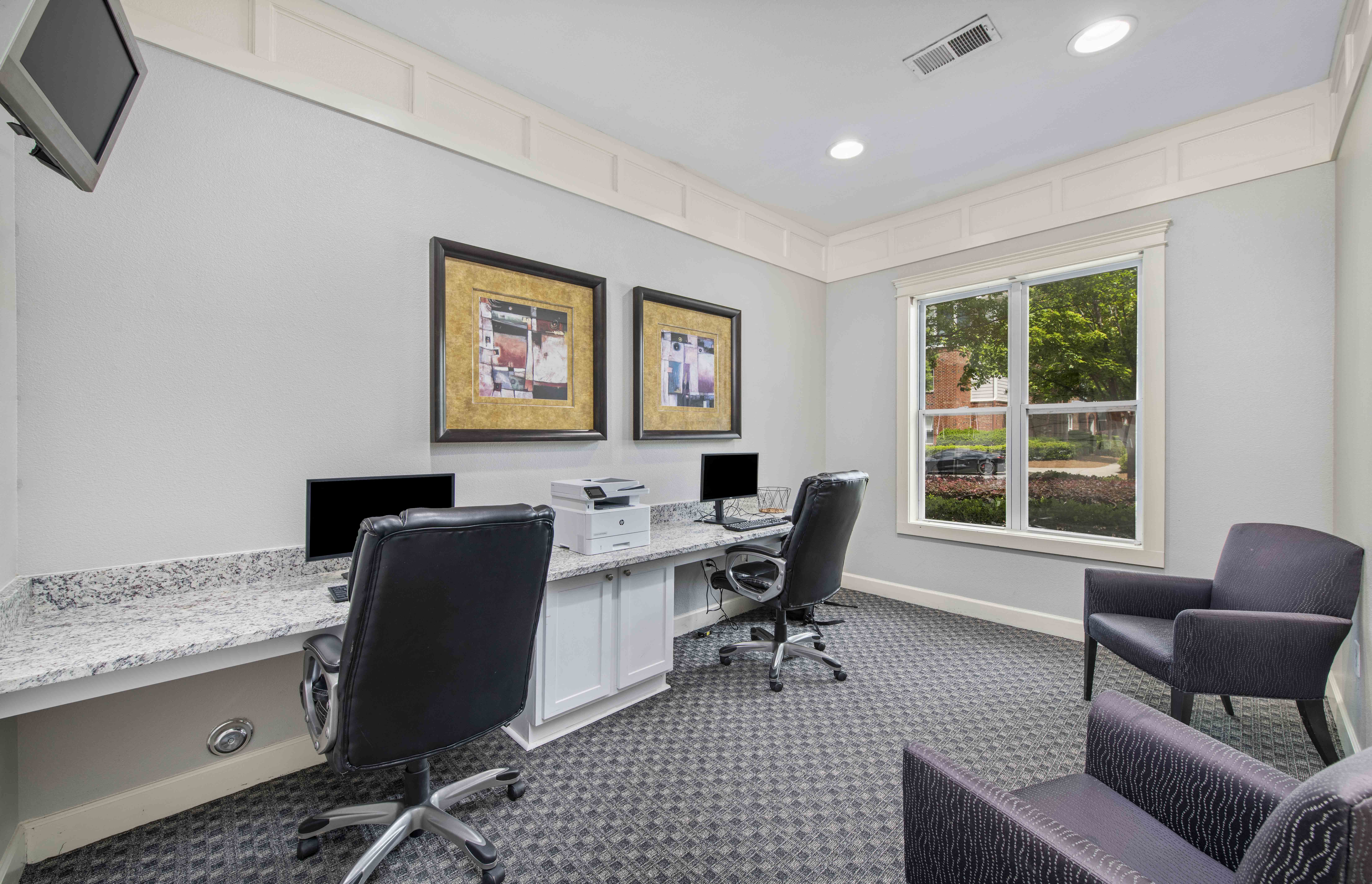 a conference room with two desks and chairs and a window