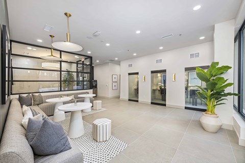 A modern living room with a grey sofa and a white coffee table.
