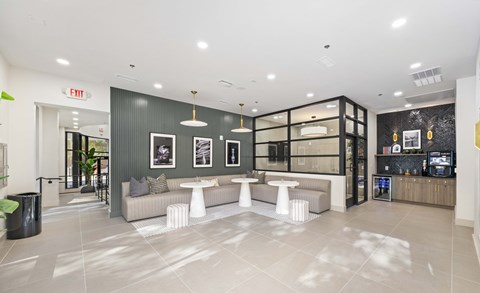 A modern lobby with a grey couch and a white coffee table.