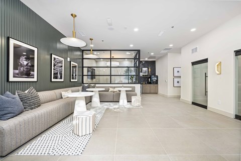 A modern living room with a grey sofa, a coffee table, and a glass display cabinet.