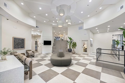 A spacious lobby with a checkered floor and a variety of seating options.