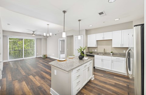 A kitchen with white cabinets and a wooden floor.