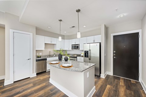A modern kitchen with a center island and stainless steel appliances.