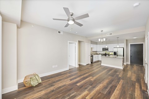 A room with a ceiling fan and wooden floors.