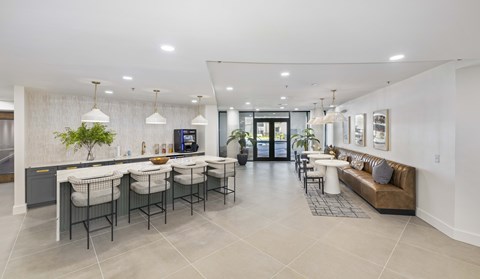A modern living room with a kitchen area in the background.