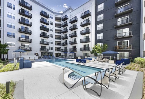A large swimming pool in front of apartment buildings.