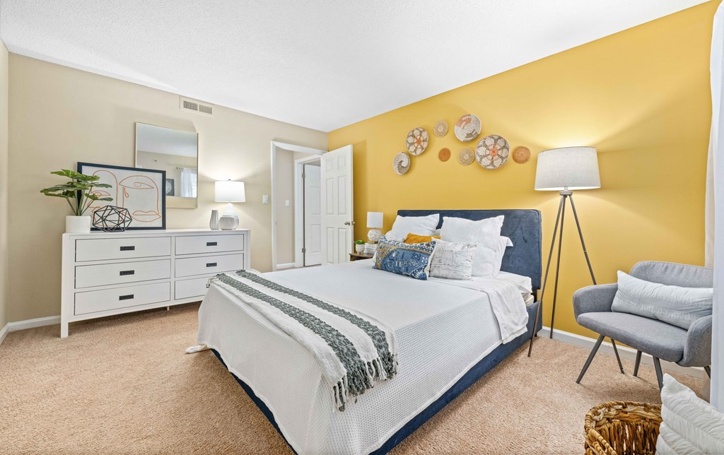 a bedroom with yellow walls and a white bed