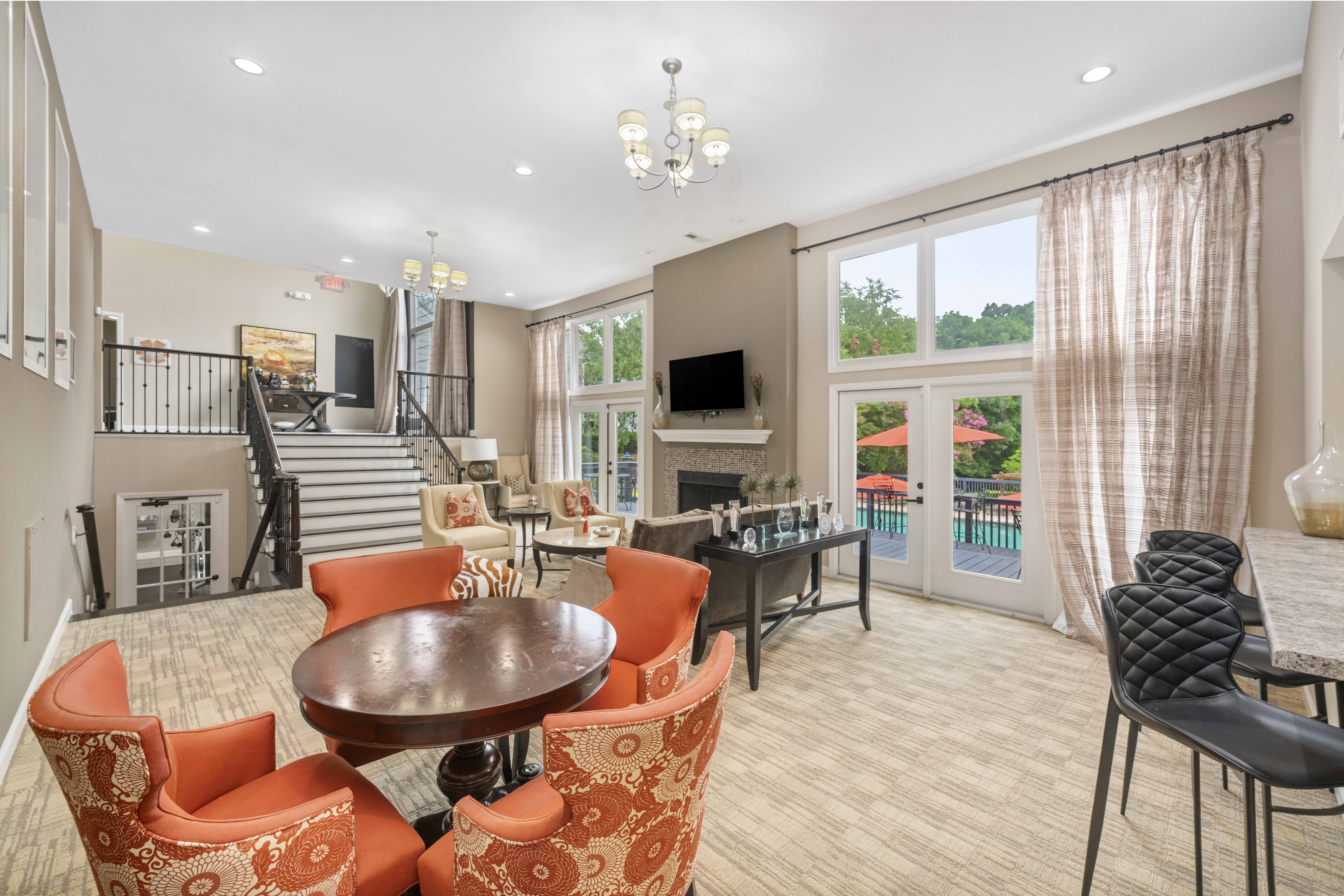 a living room with chairs and a table and a staircase