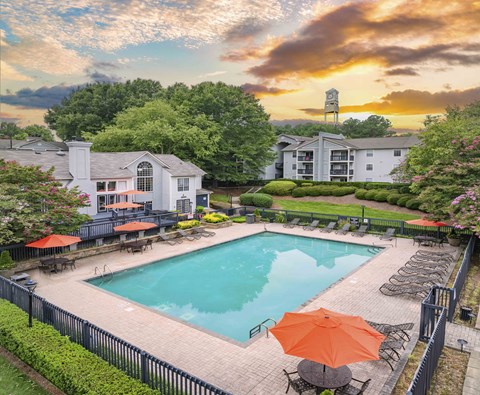 a swimming pool with an umbrella in front of a building