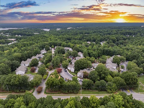 an aerial view of a neighborhood with houses and trees at sunset