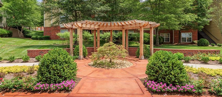 a garden with a wooden gazebo