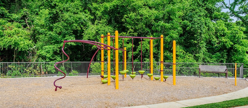a playground with a swing set and a bench