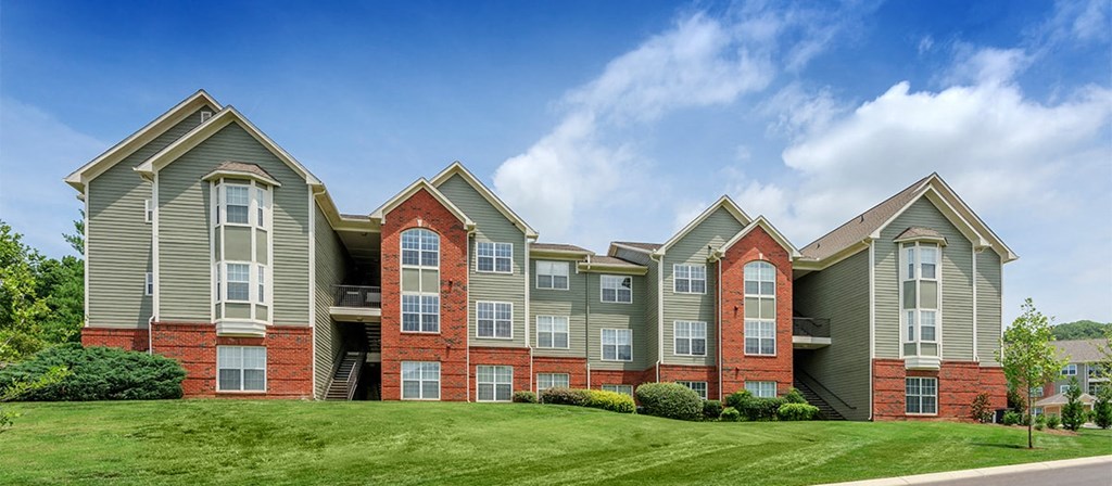 an apartment building with red brick and green siding