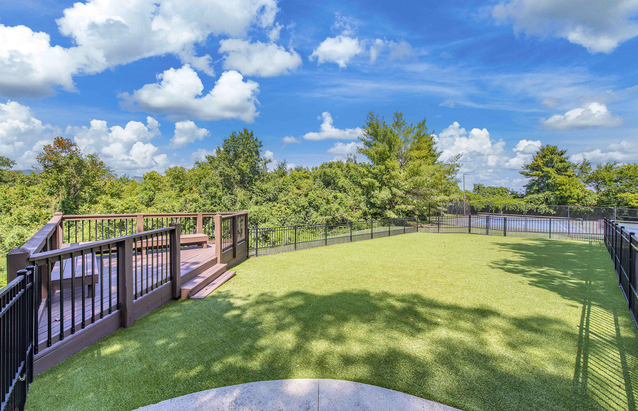 a fenced in backyard with a lawn and a fence