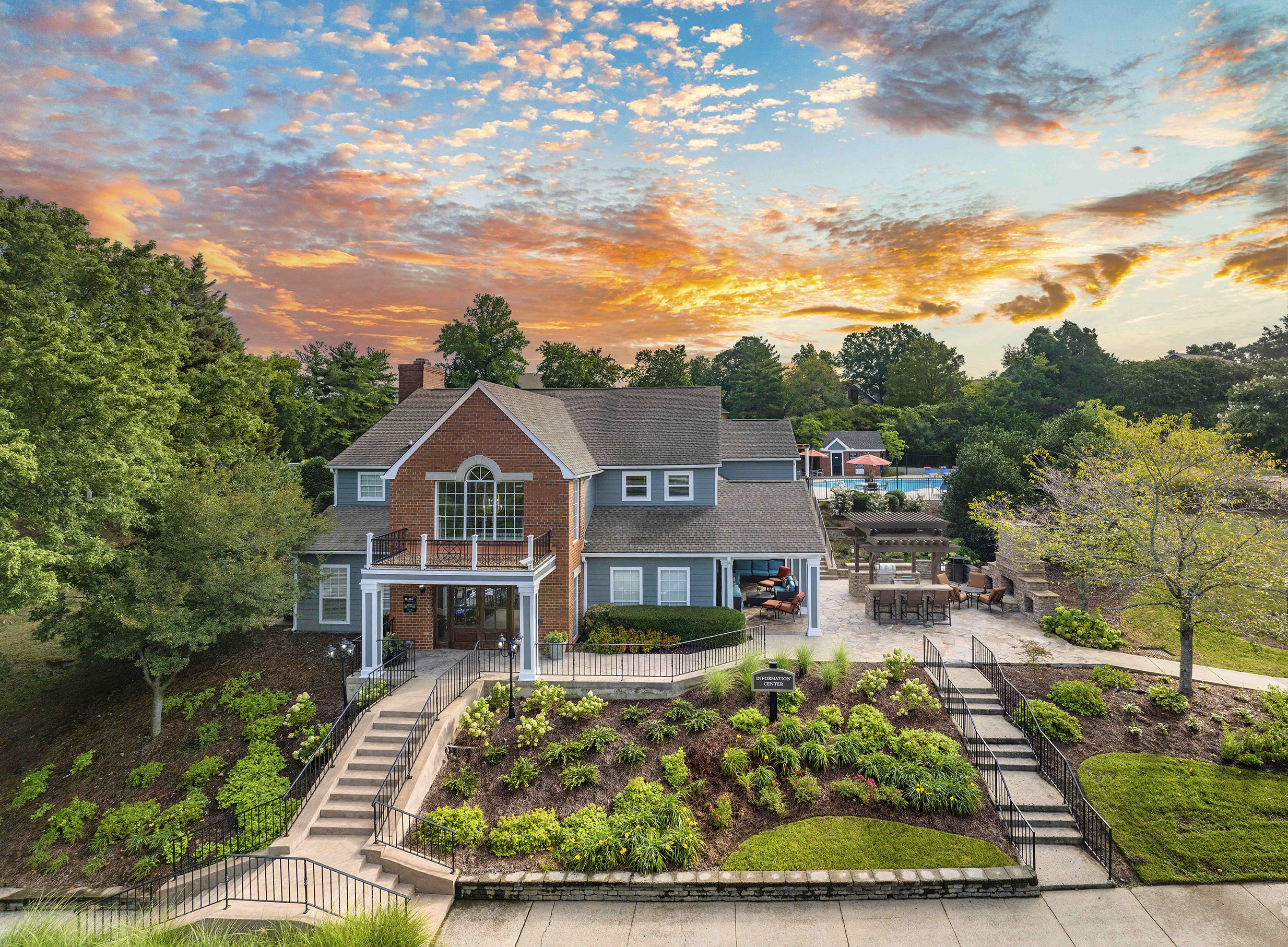 an aerial view of a house with a garden and a sunset