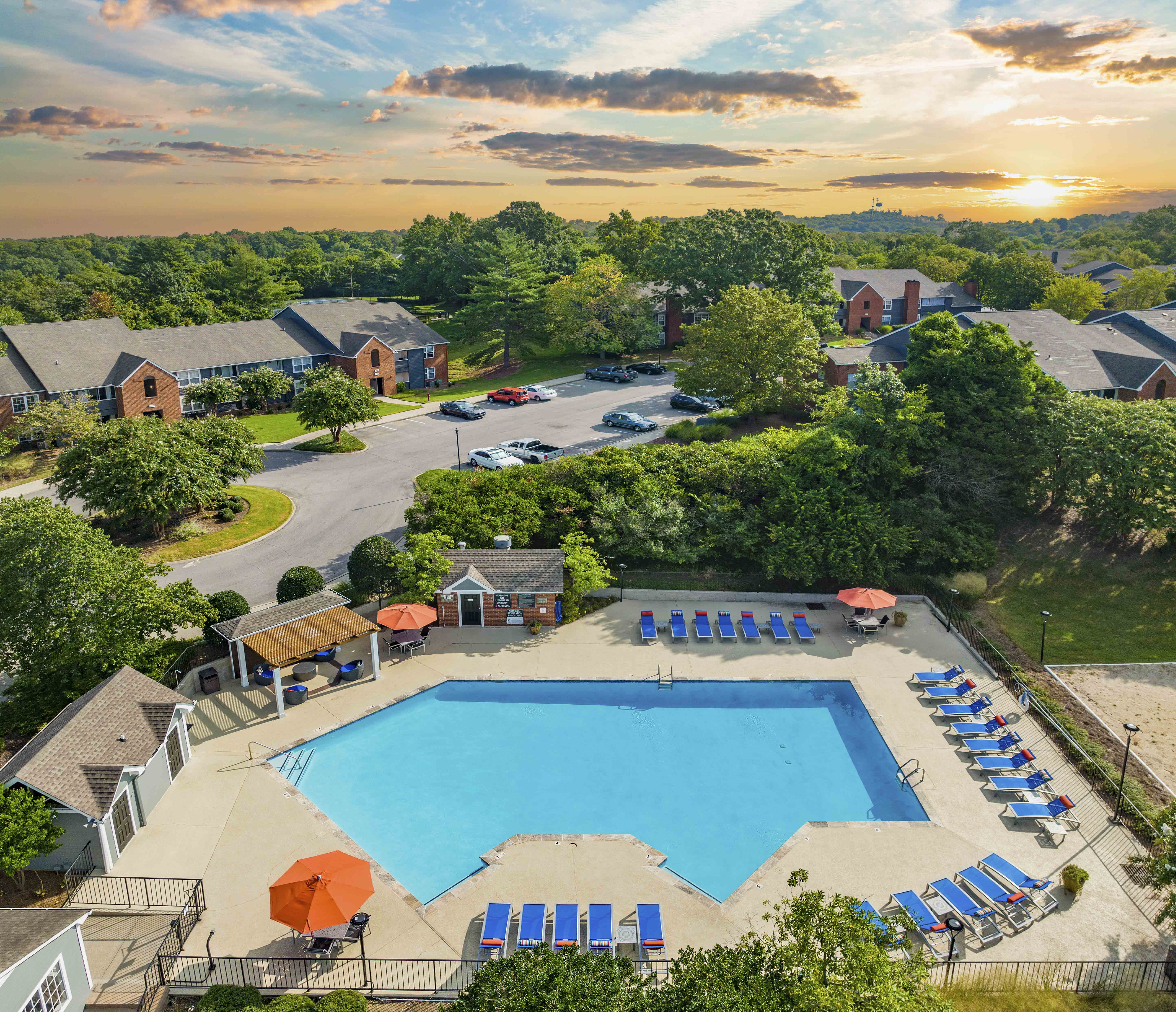 an aerial view of a swimming pool with lounge chairs at sunset