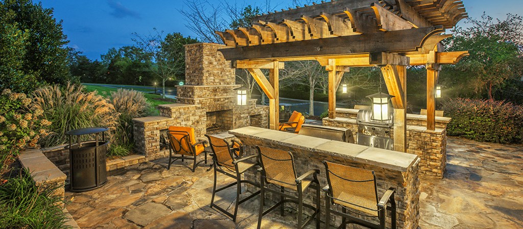 a backyard patio with a bar and a grill