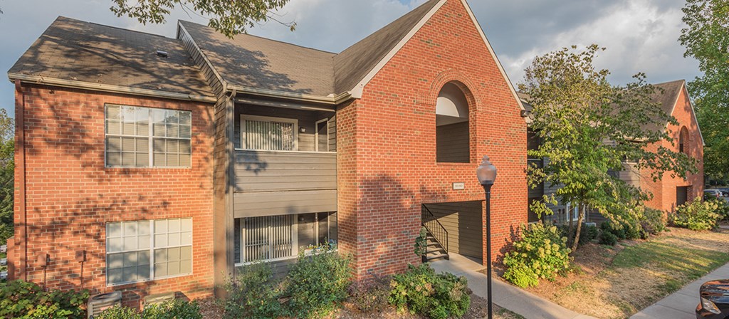 exterior view of a brick house with a sidewalk and a street light