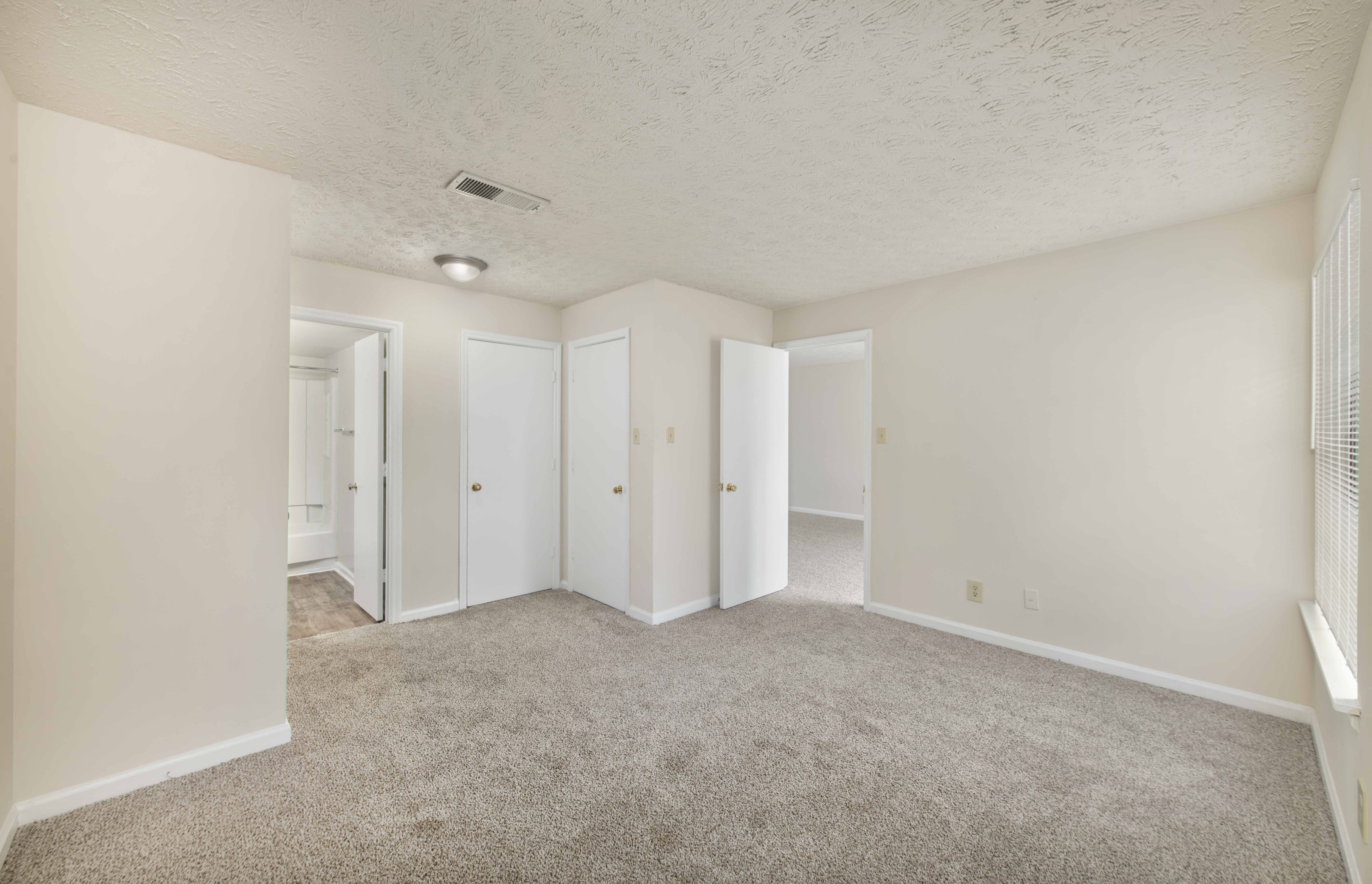 an empty living room with white walls and carpet