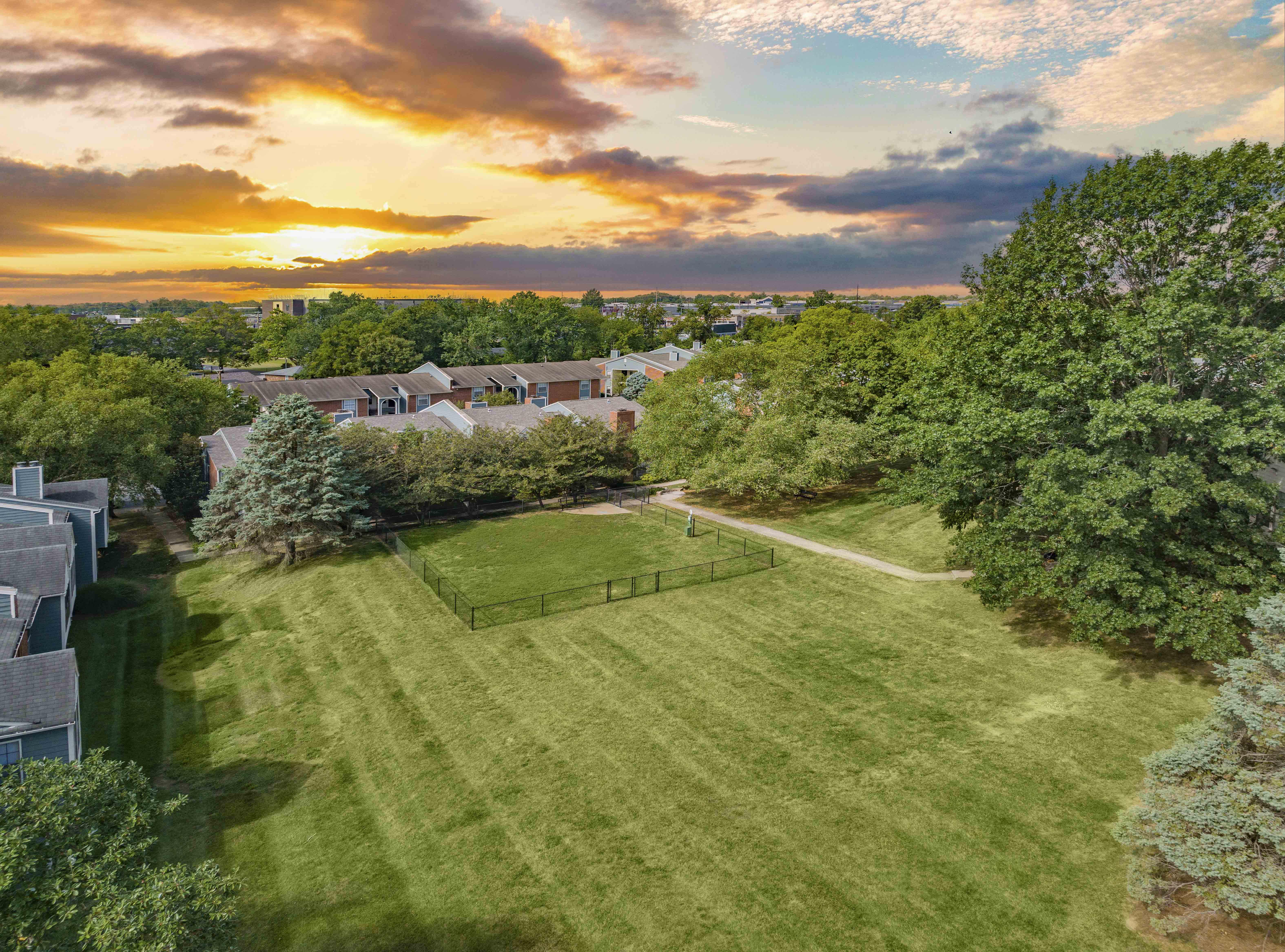 a backyard with a soccer field and a sunset in the sky