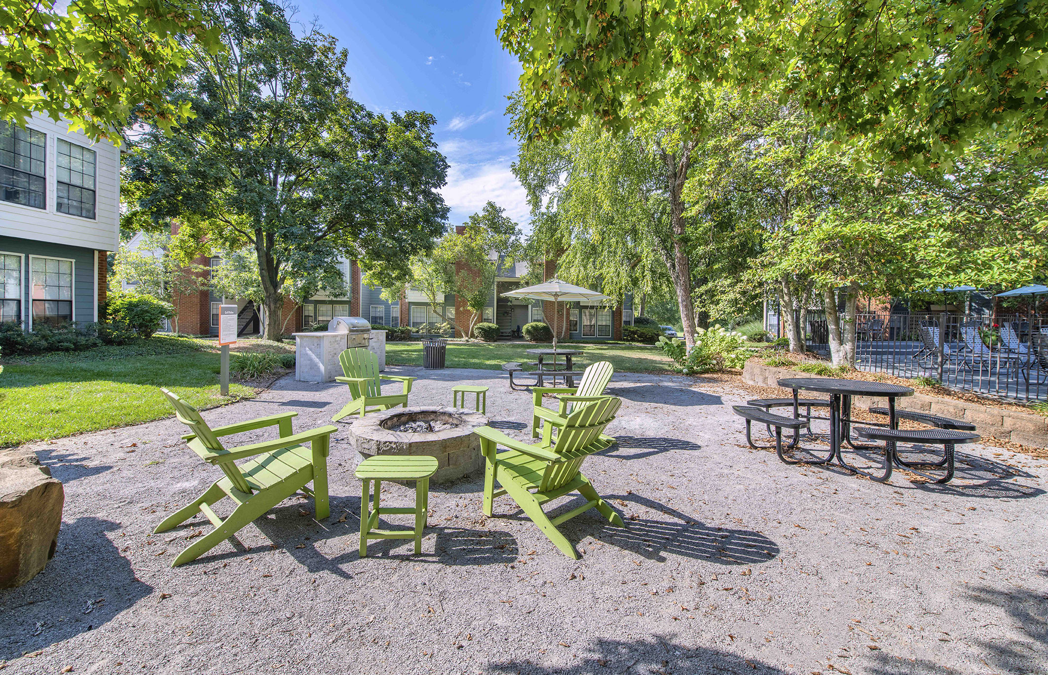 a patio with chairs and tables and a fire pit
