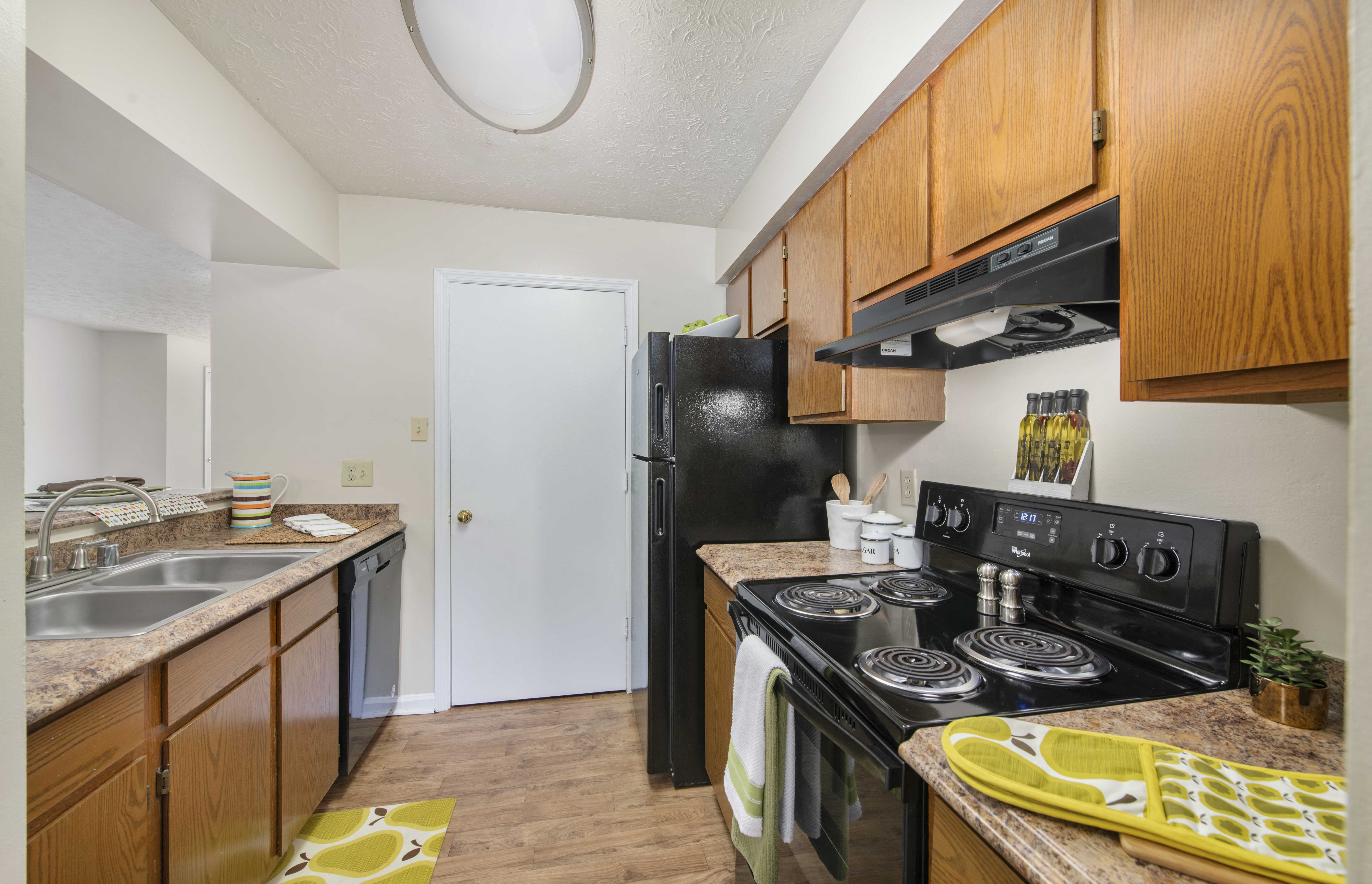a kitchen with black appliances and wooden cabinets and a black refrigerator