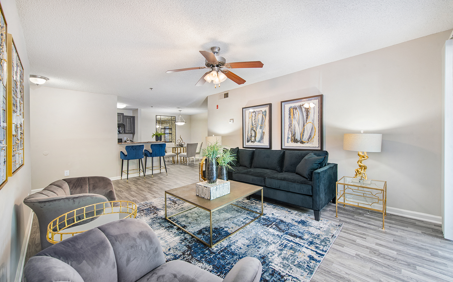 a living room with couches and a coffee table and a ceiling fan