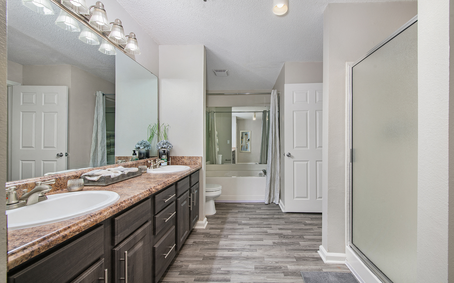 an open bathroom with two sinks and a shower and a toilet