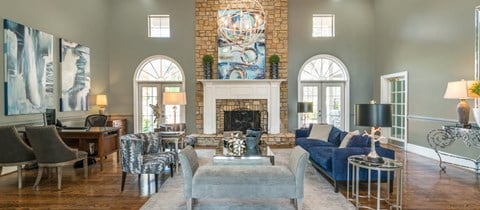 a living room with blue furniture and a brick fireplace