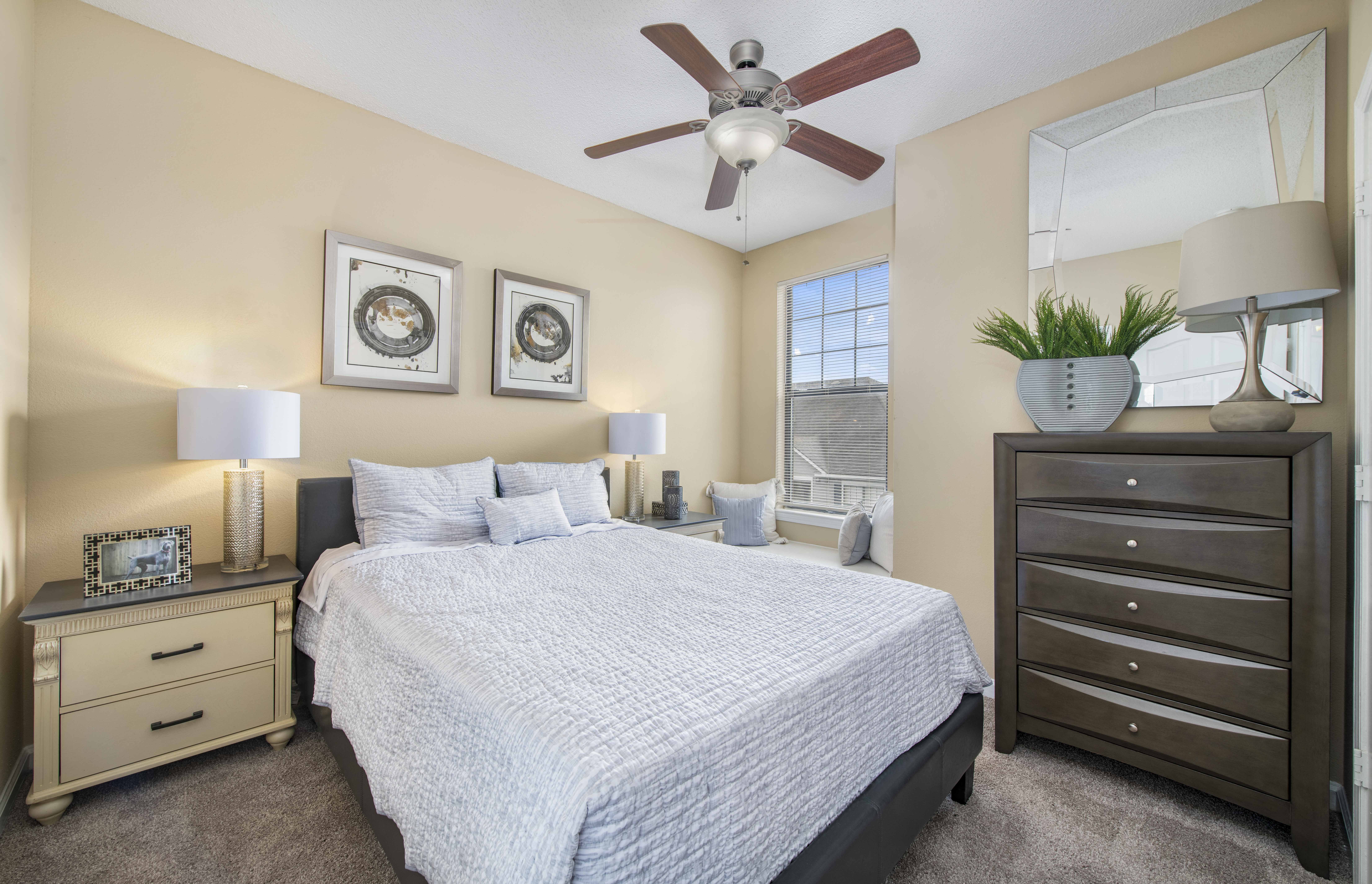 a bedroom with a bed and a ceiling fan