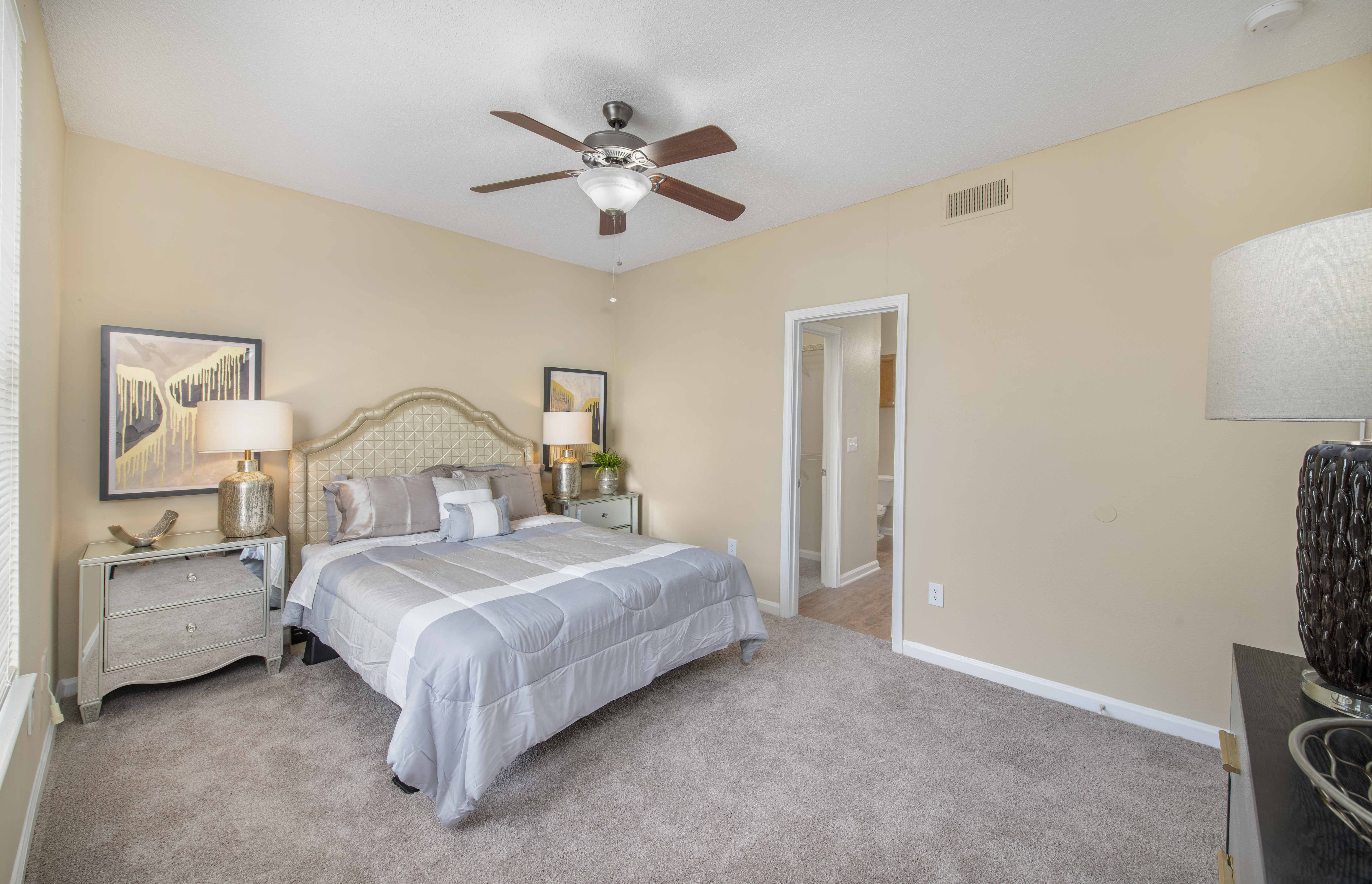 a bedroom with a bed and a ceiling fan
