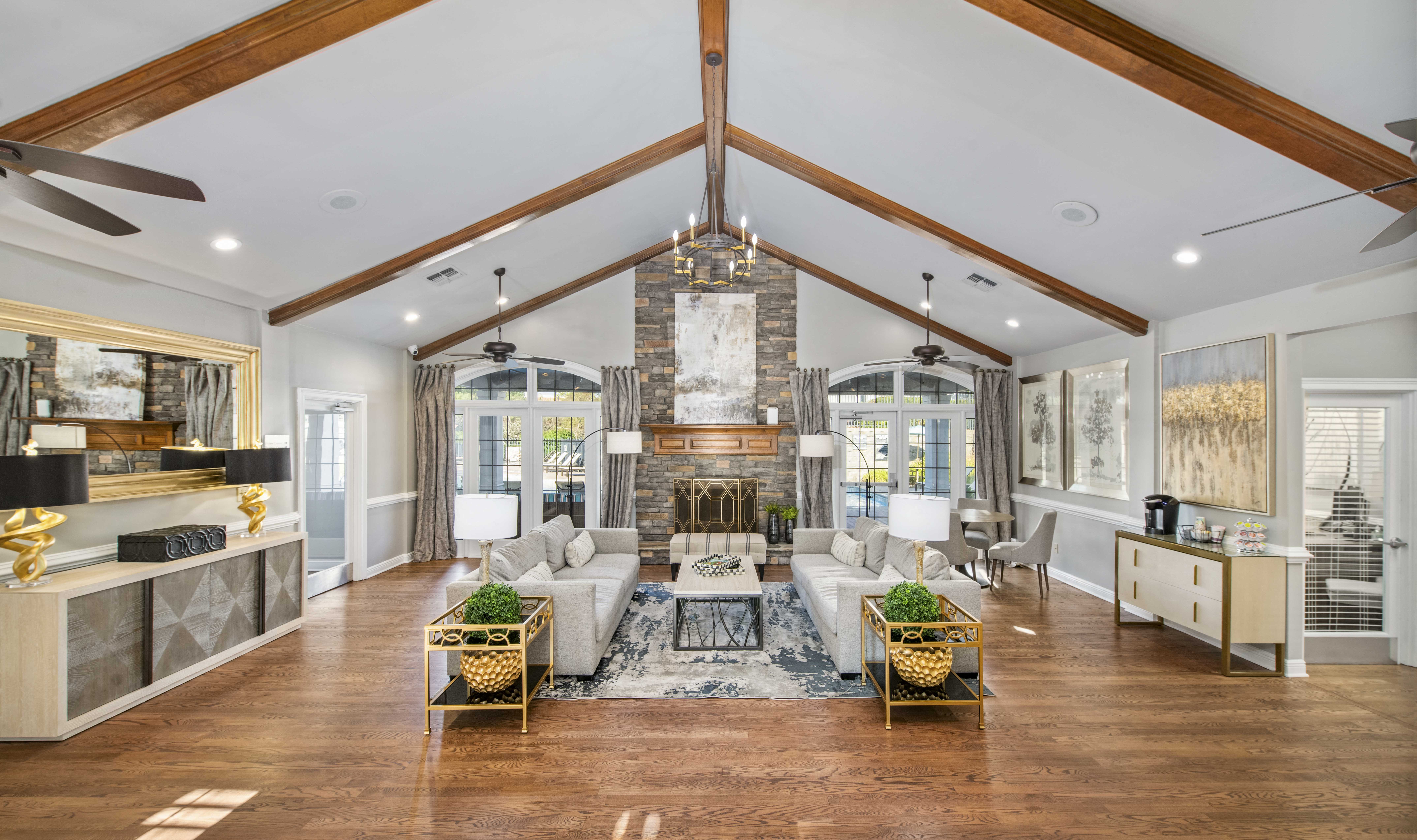 a living room with a large fireplace and a ceiling with exposed beams