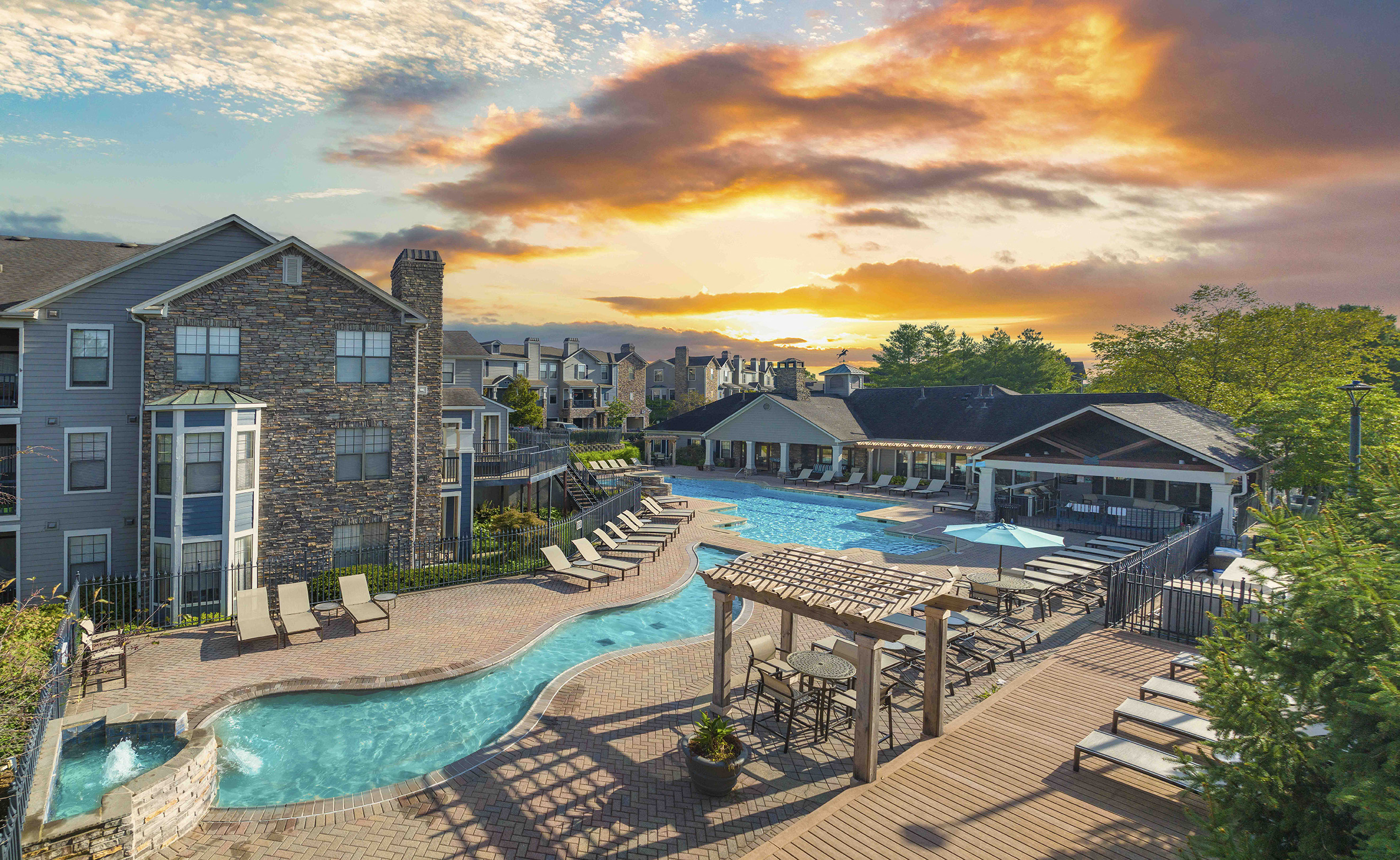 a swimming pool at a resort with a sunset in the background