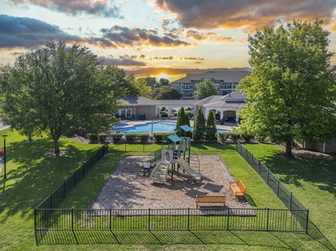 an aerial view of a playground with trees and a pool at sunset