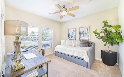 a bedroom with a bed and a ceiling fan