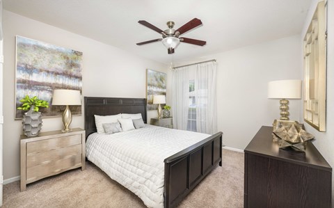a bedroom with a bed and a ceiling fan