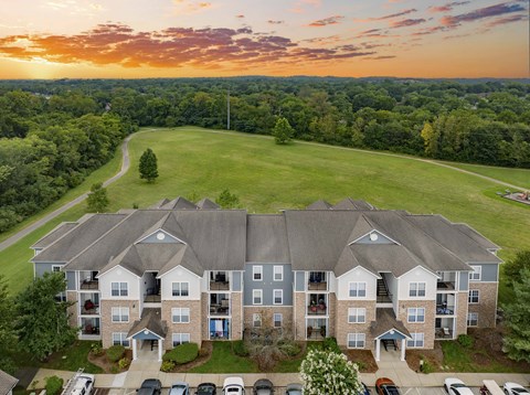 an aerial view of an apartment building with a sunset in the background