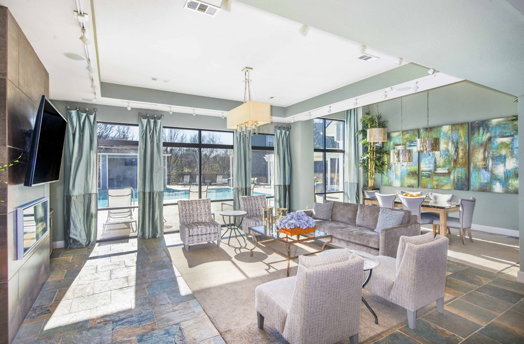 a living room with a couch and chairs and a tv