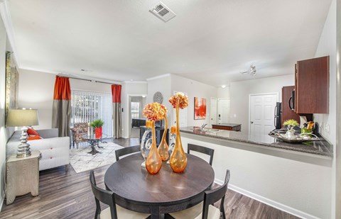 a living room with a dining room table and a kitchen