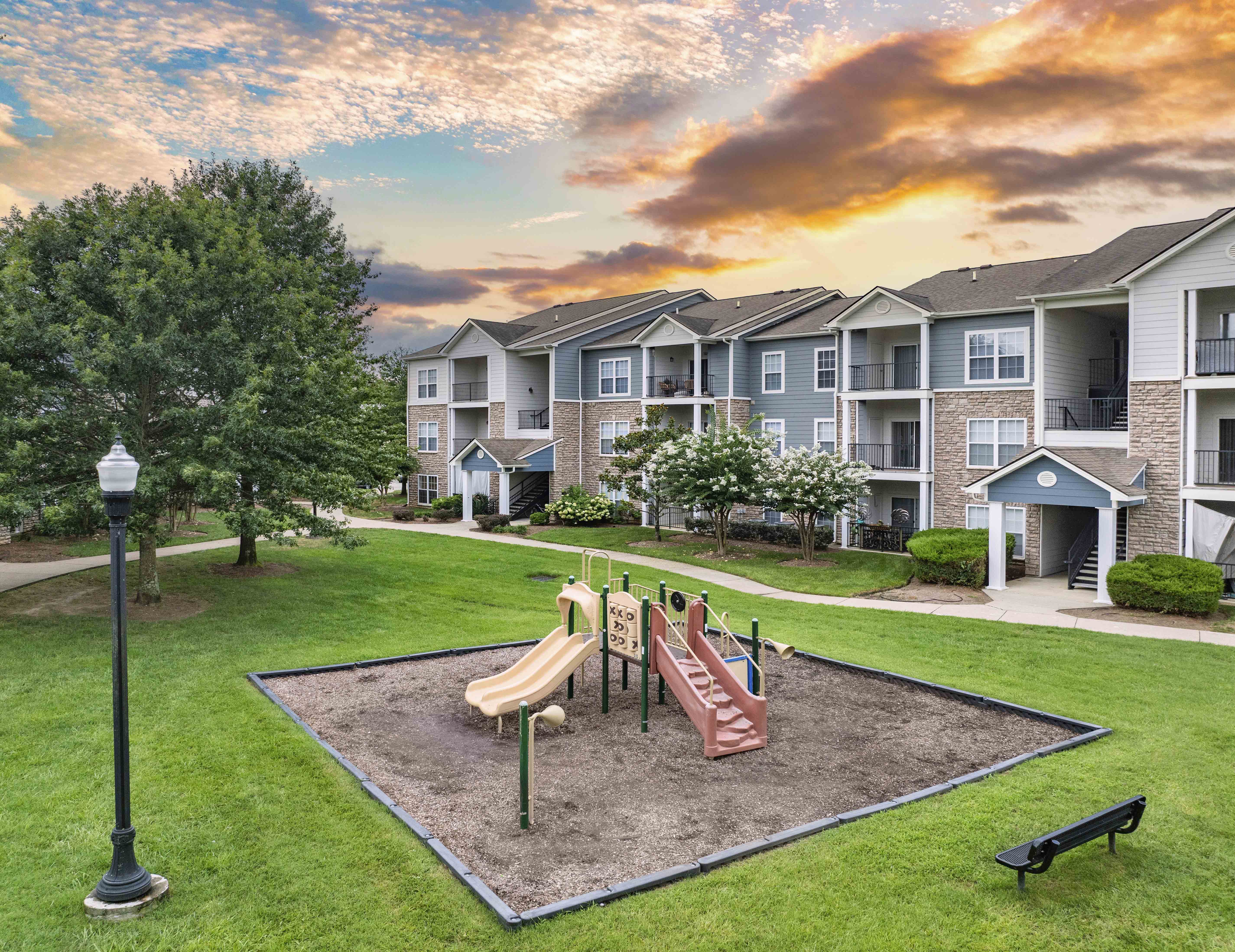 a playground at the preserve at sunset in front of an apartment building