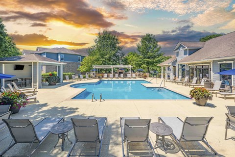 a swimming pool with chairs around it and a house with a pool