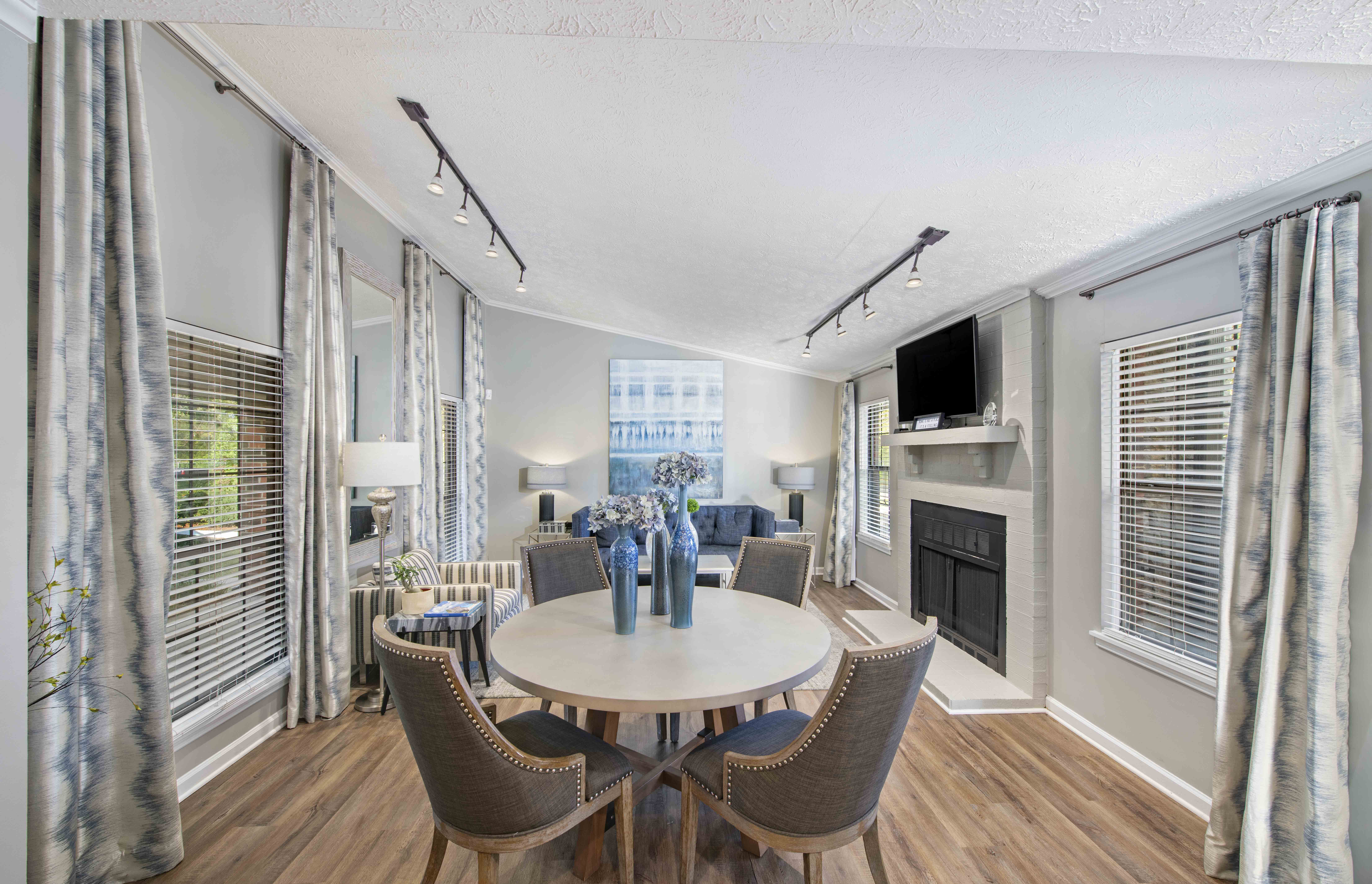 a living room with a table and chairs and a fireplace
