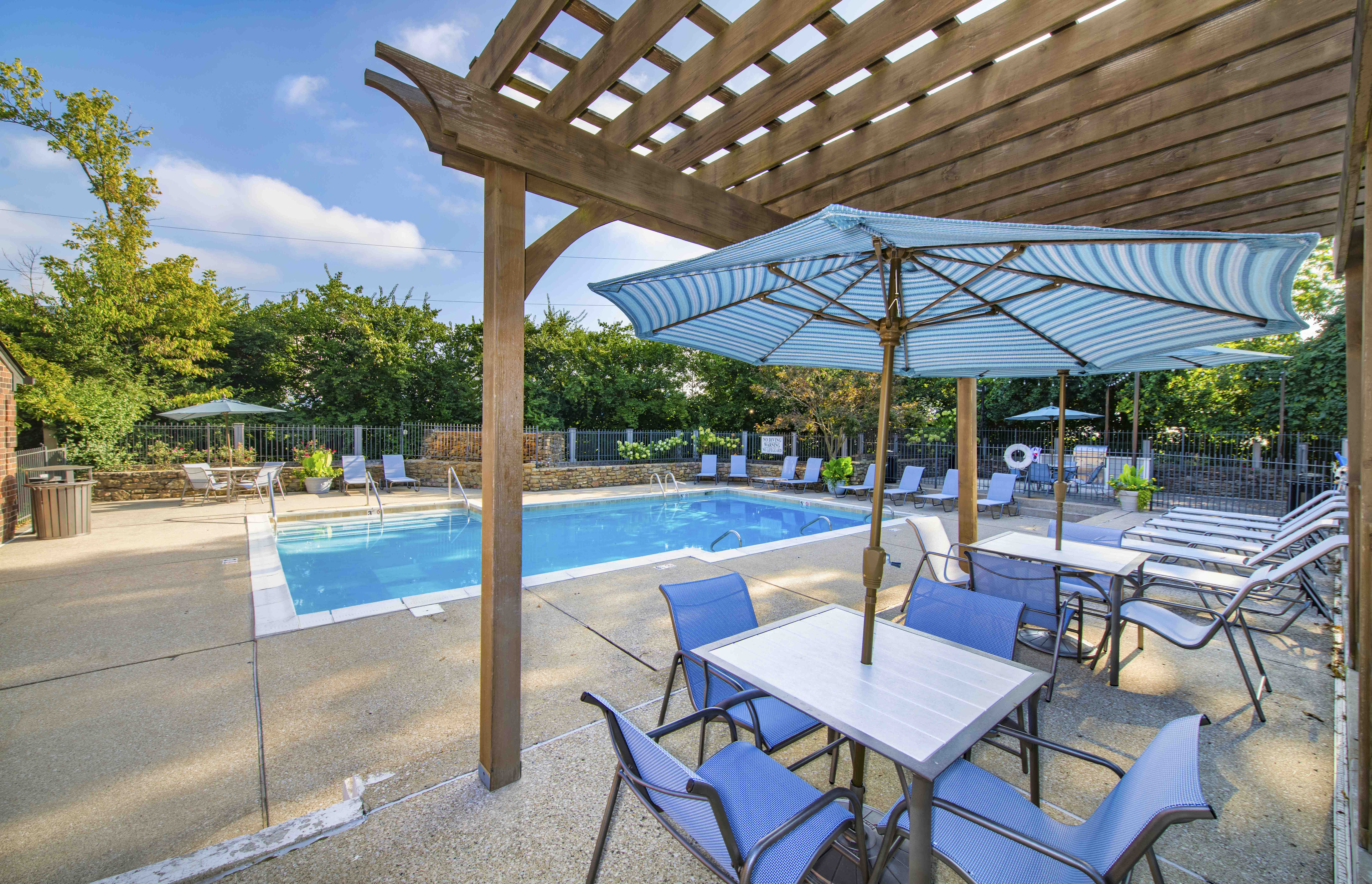 a patio with tables and chairs and a swimming pool